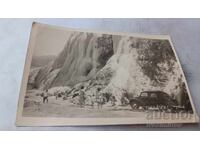 Fotografie bărbați, femei și copii lângă o cascadă înghețată
