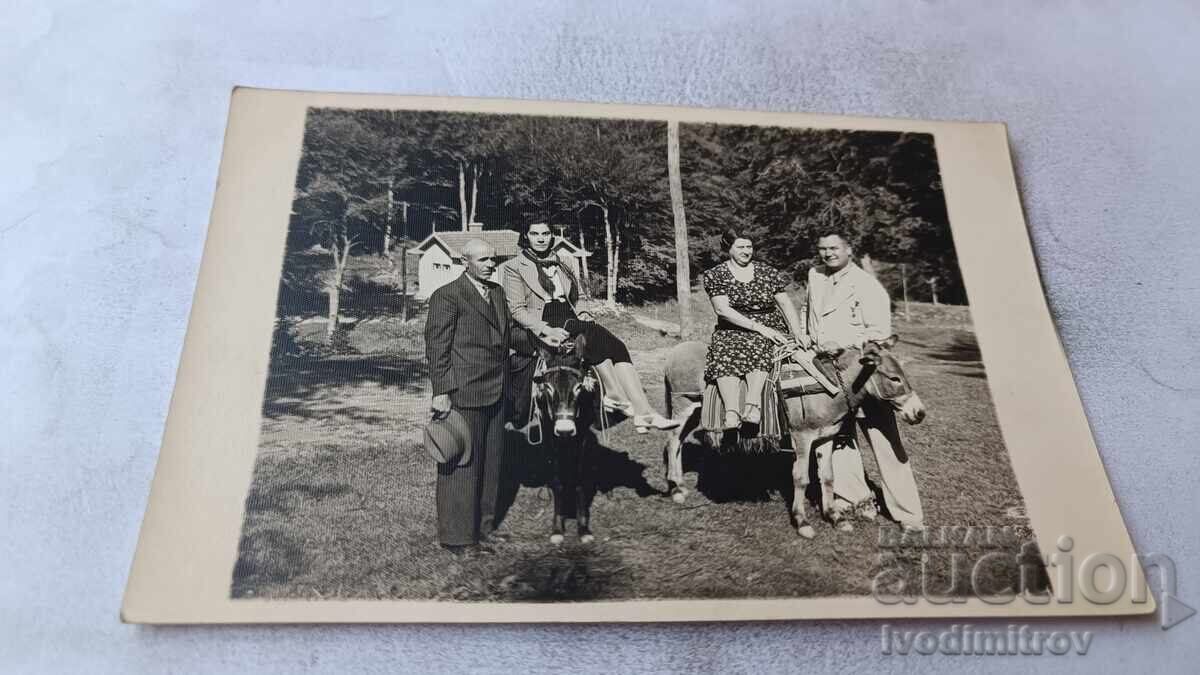 Fotografie Bărbați și două femei pe măgari