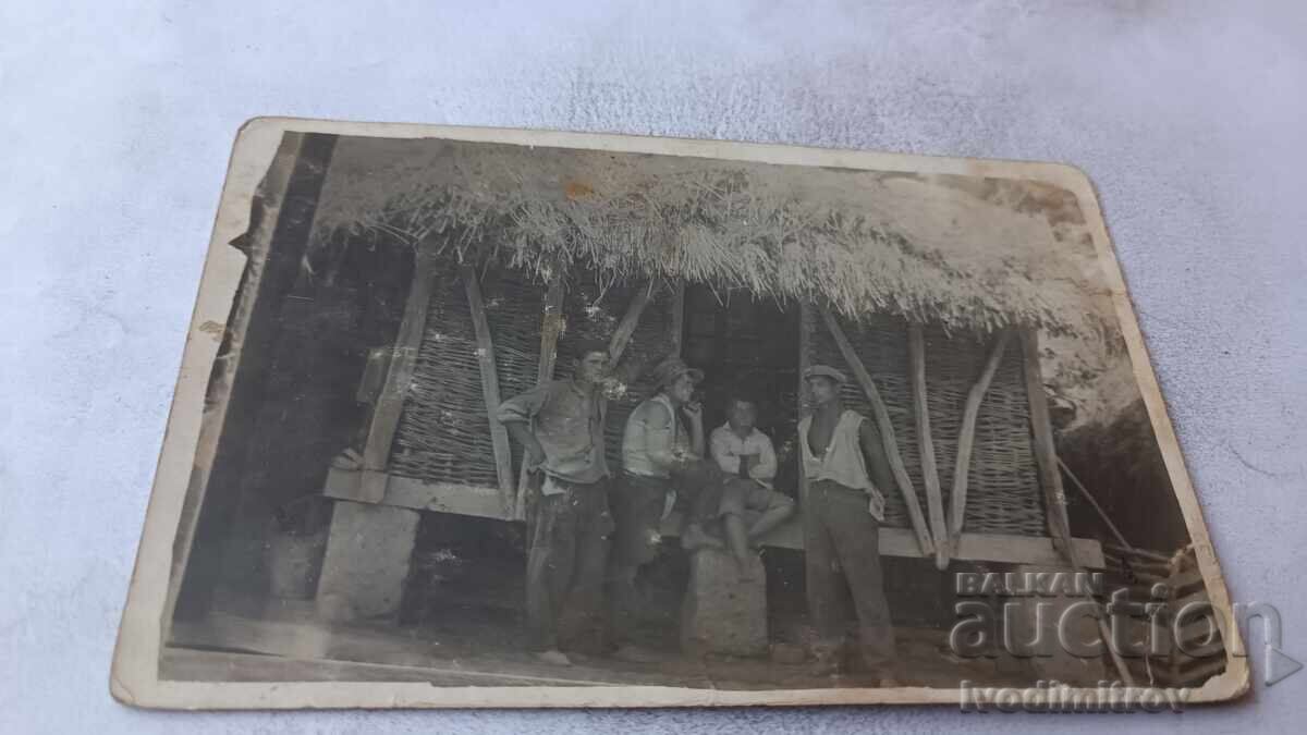 Fotografie Trei bărbați și un băiat lângă un depozit de porumb