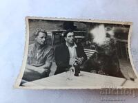 Fotografie Doi bărbați și un urs în jurul unei mese de lemn