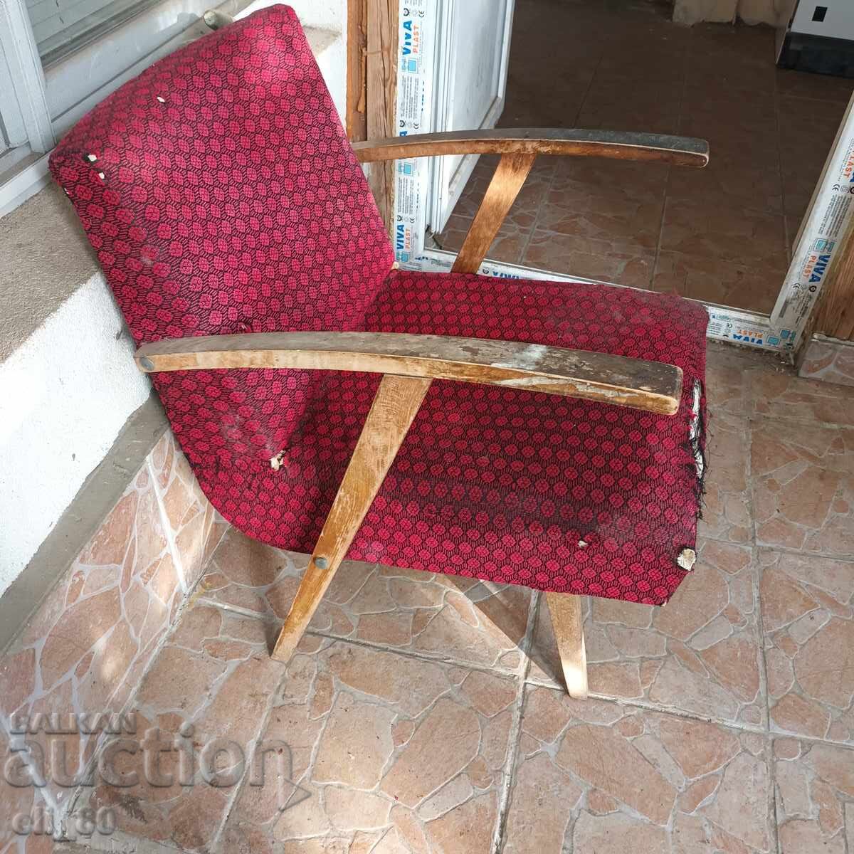 Παράδοση Παλιά ρετρό ξύλινη πολυθρόνα. Το ύφασμα στο μπροστινό μέρος είναι σκισμένο