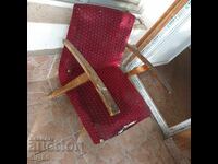 Old retro wooden armchair. The upholstery in the front is torn