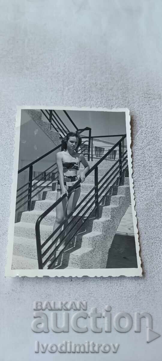 Fotografie tânără fată pe scările unei piscine