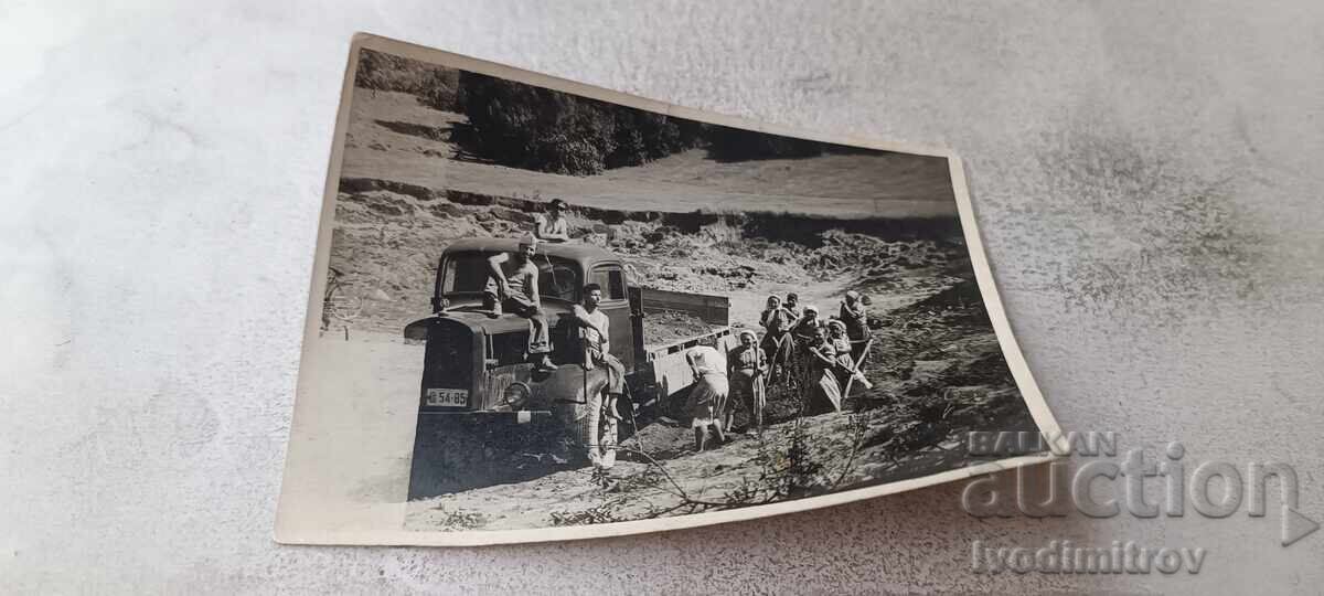 Fotografie bărbați și femei cu un camion retro cu nr. Sf 54-85