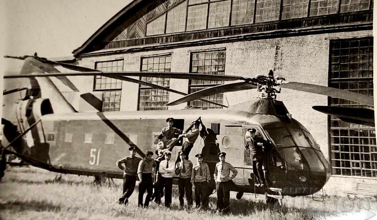 Licitație Această fotografie înfățișează un grup de militari în fața unui elicopter sovietic
