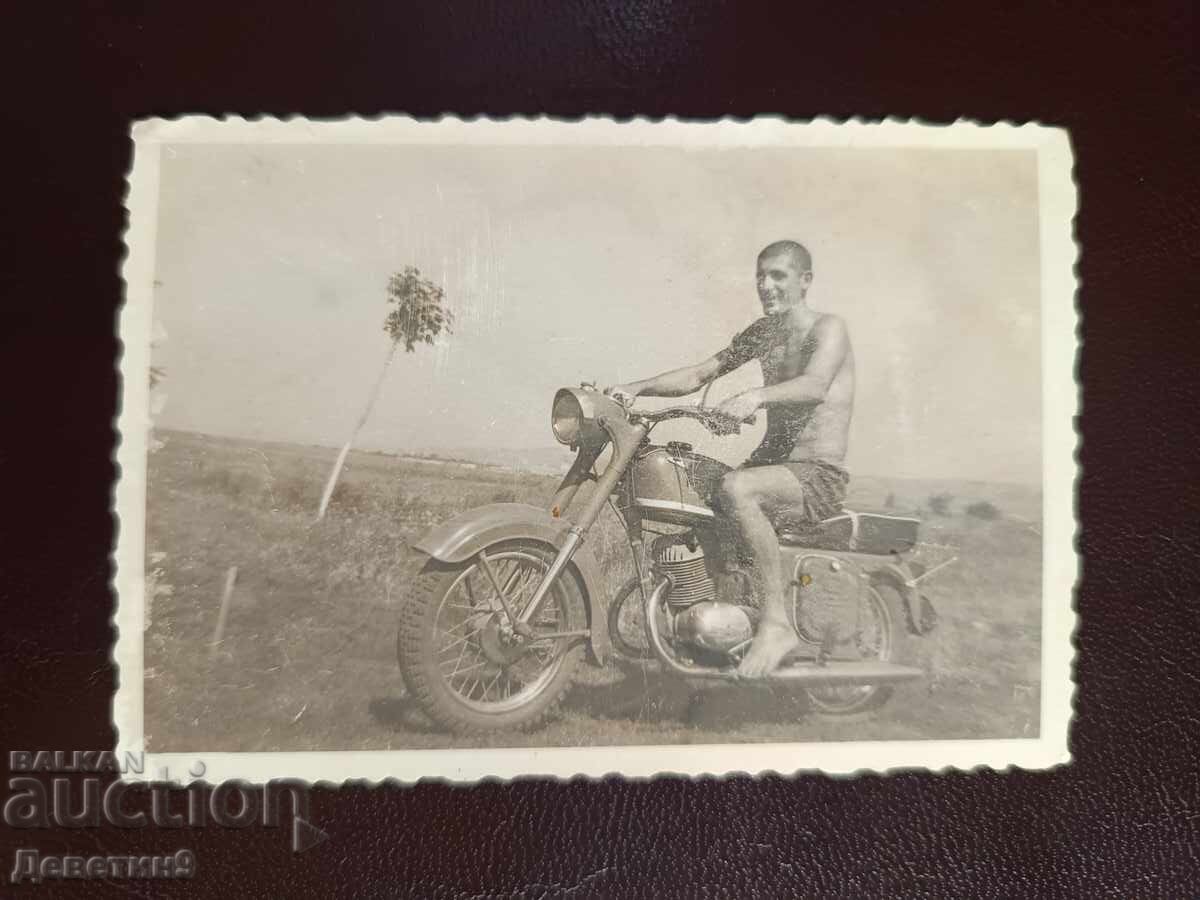 Bărbat cu motocicletă pe câmp