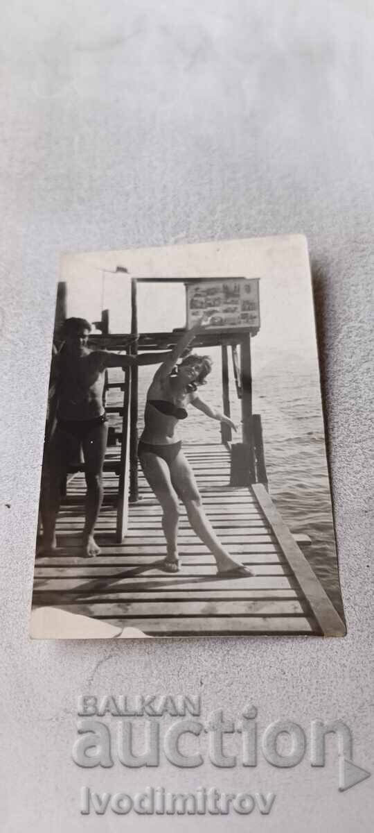 Fotografie Tânăr și tânără pe debarcader