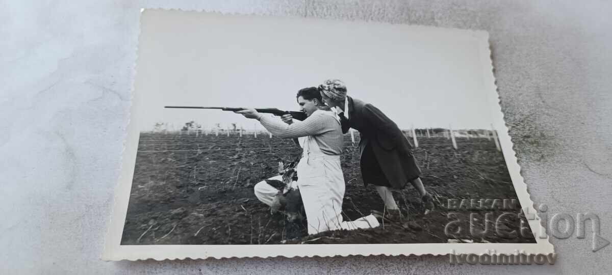 Fotografie tânără și bărbat cu pușcă cu aer comprimat