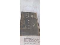 Fotografie tânăr cu un câine negru stând pe o bancă de lemn