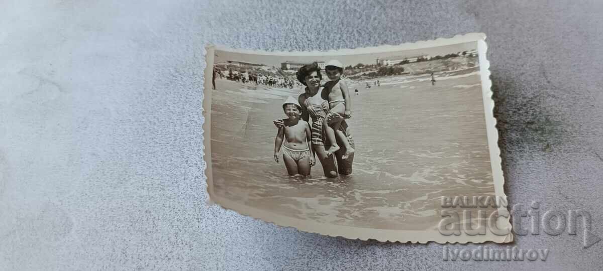 Fotografie femeie, fetiță și băiețel pe malul mării