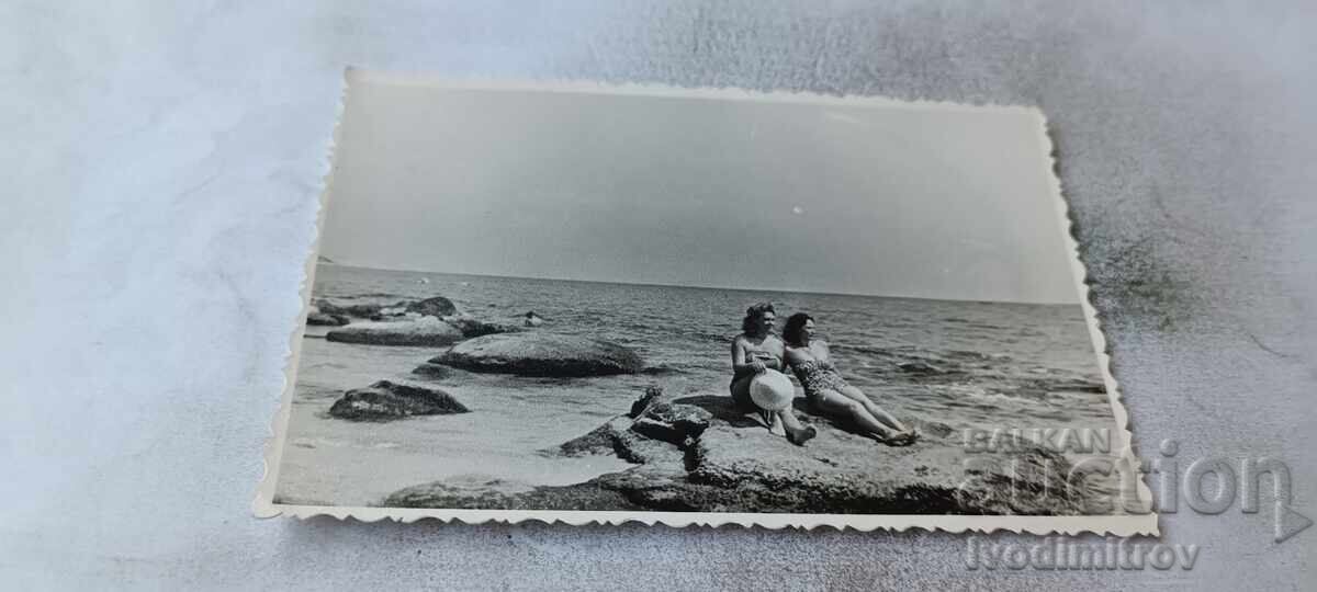 Photo Two women on a rock by the sea