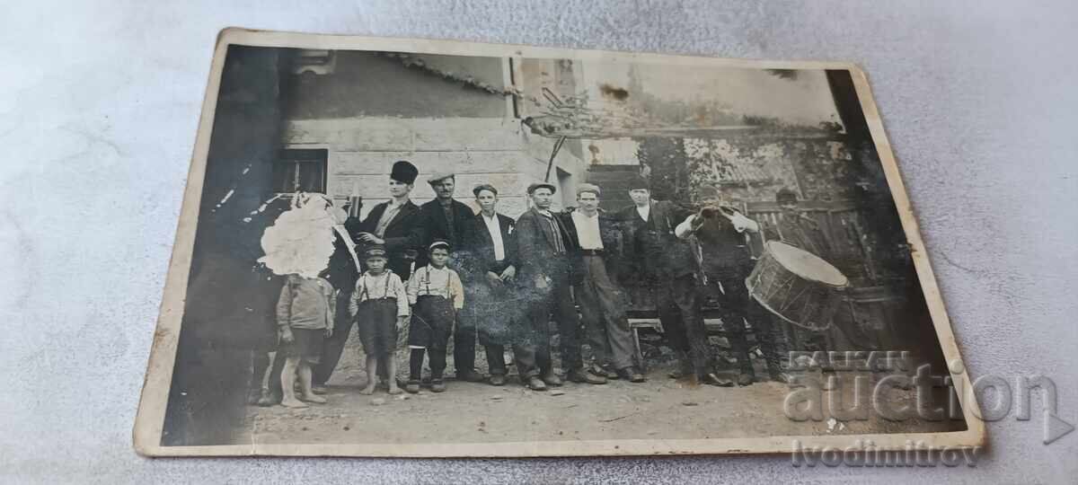 Photo Men children and a man with a drum in the yard of the house Photo Men children and a man with a drum in the yard of the house