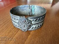 Old bronze bracelet with a flower