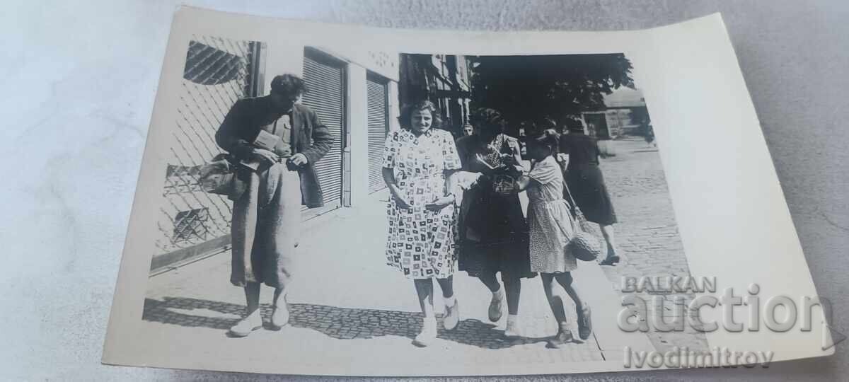 Fotografie bărbat, două femei și o fată pe trotuar Fotografie bărbat, două femei și o fată pe trotuar