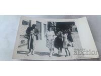 Fotografie bărbat, două femei și o fată pe trotuar