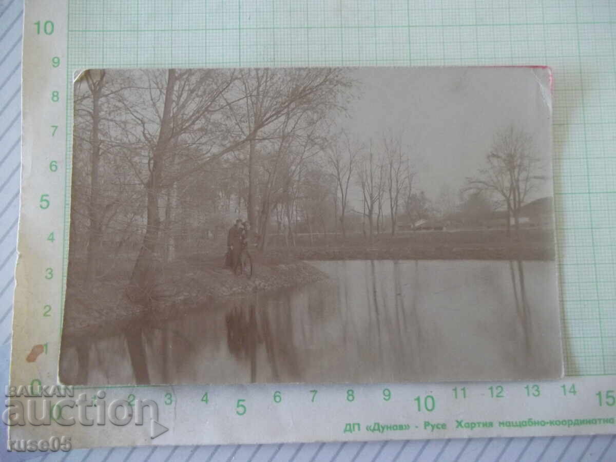 Photo of a uniformed man with a woman by the water, old Photo of a uniformed man with a woman by the water, old