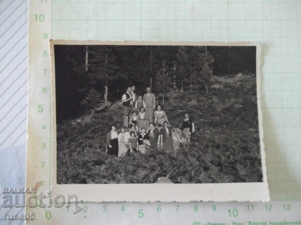 Fotografie cu un grup de turiști în natură veche