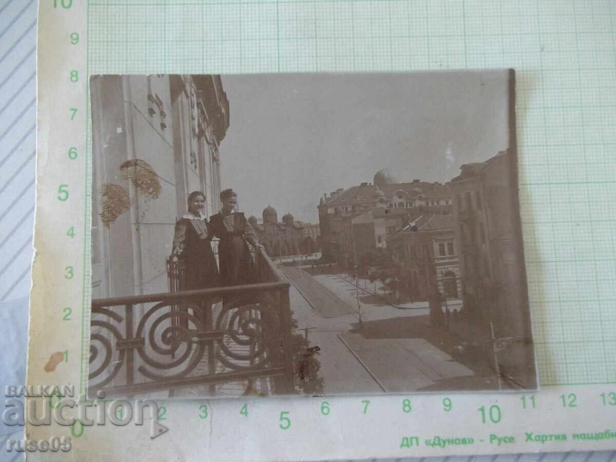 Fotografie cu două tinere pe un balcon vechi