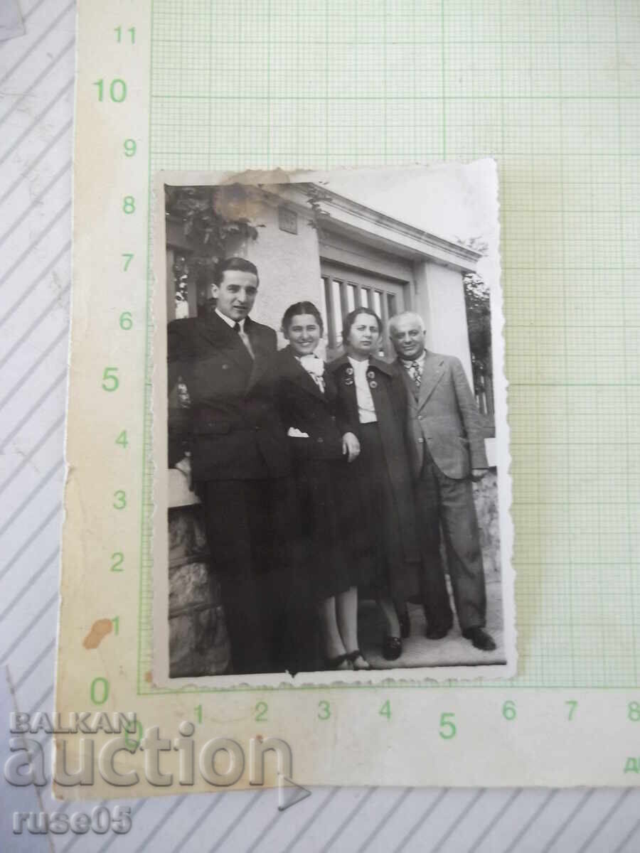 Photo of two families in front of an old building