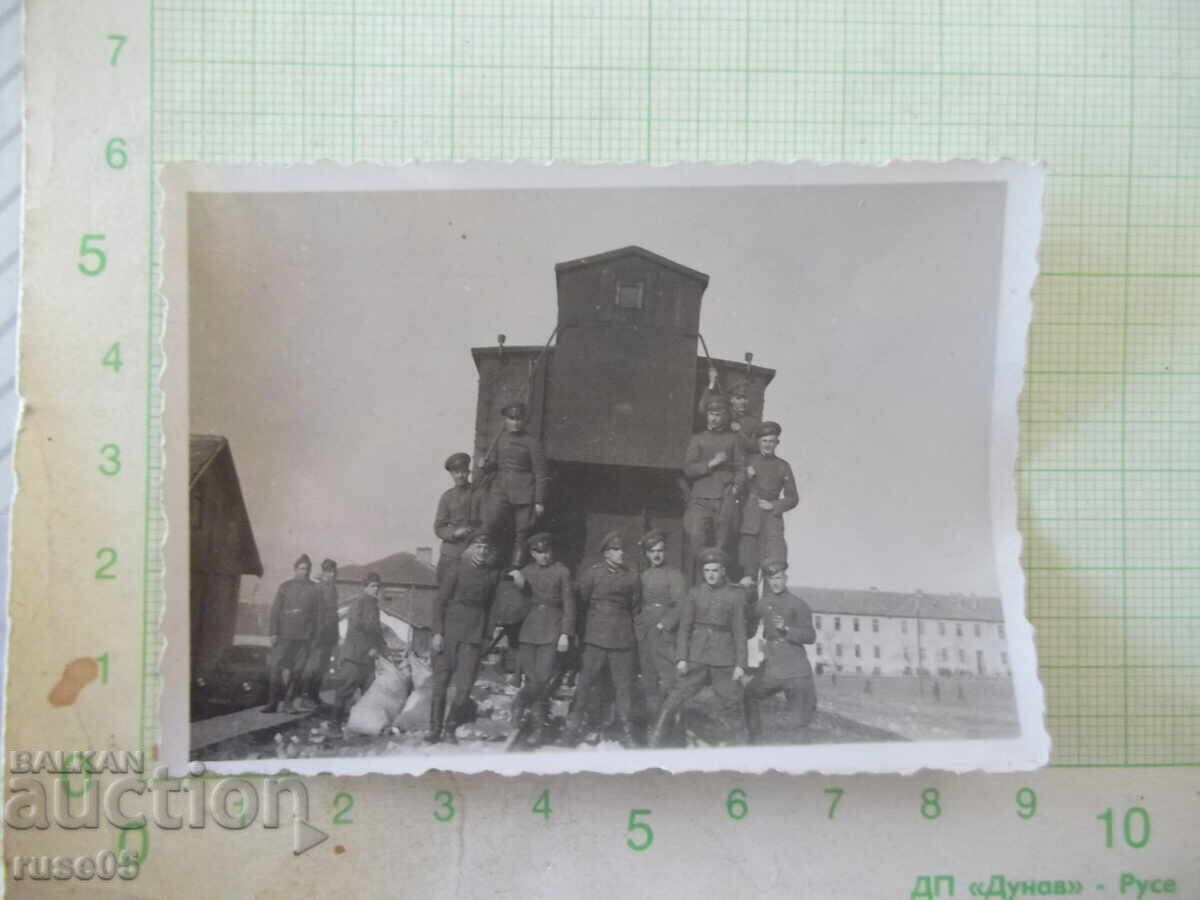 Photo of soldiers in front of an old train carriage