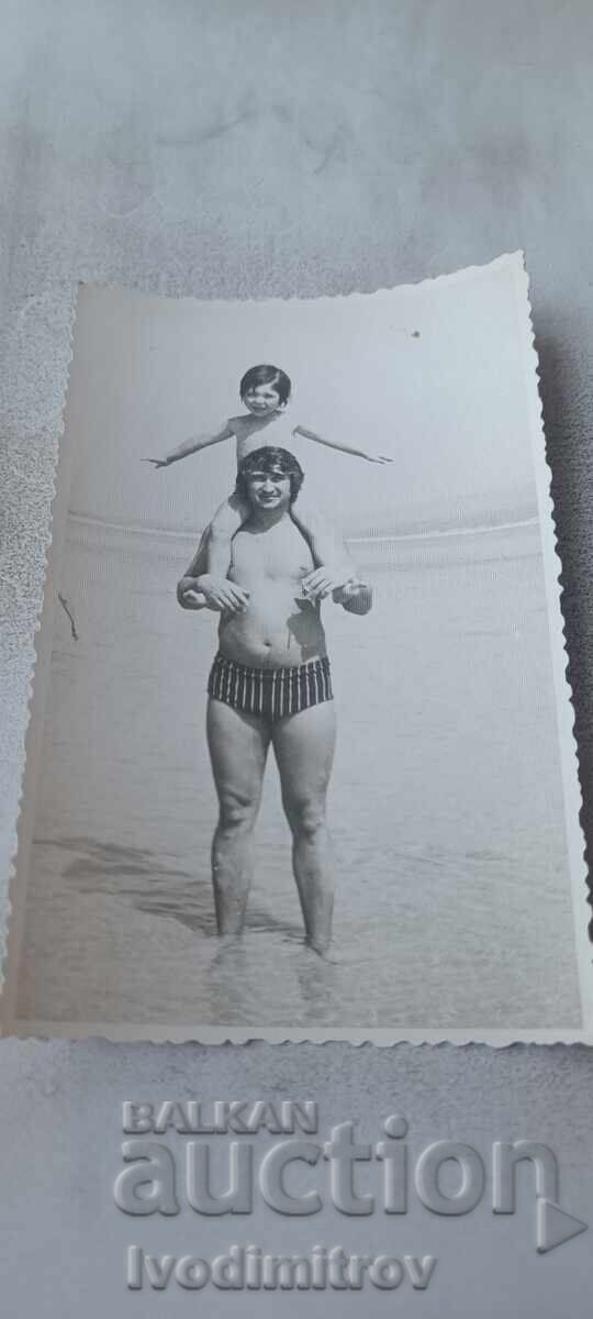 Photo Kiten Man with a little girl on his shoulders on the seashore