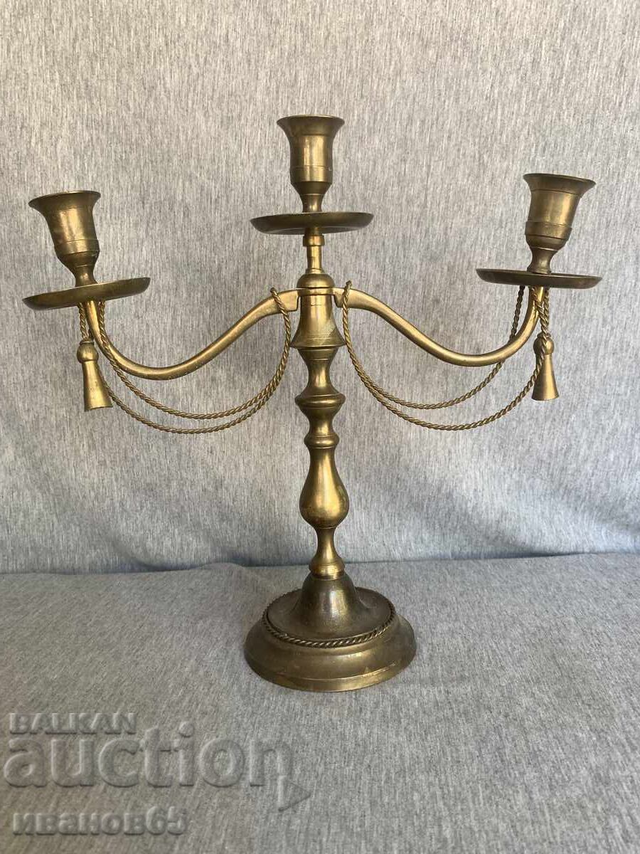 Brass candlestick with decorative ropes and tassels Brass candlestick with decorative ropes and tassels