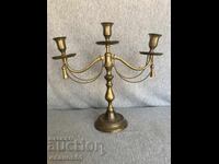 Brass candlestick with decorative ropes and tassels