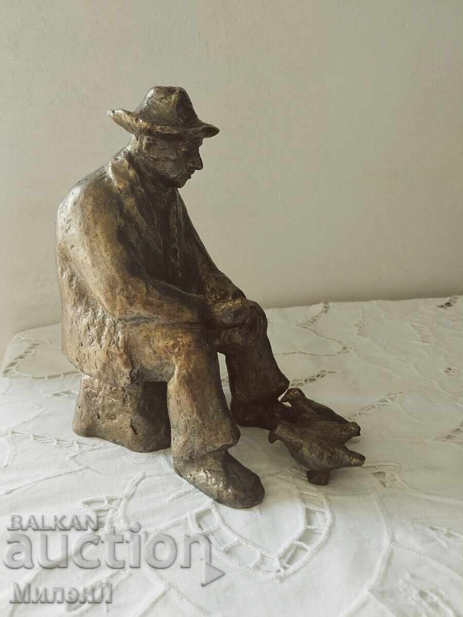Realistic sculpture of an elderly man feeding pigeons Realistic sculpture of an elderly man feeding pigeons