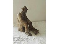 Realistic sculpture of an elderly man feeding pigeons