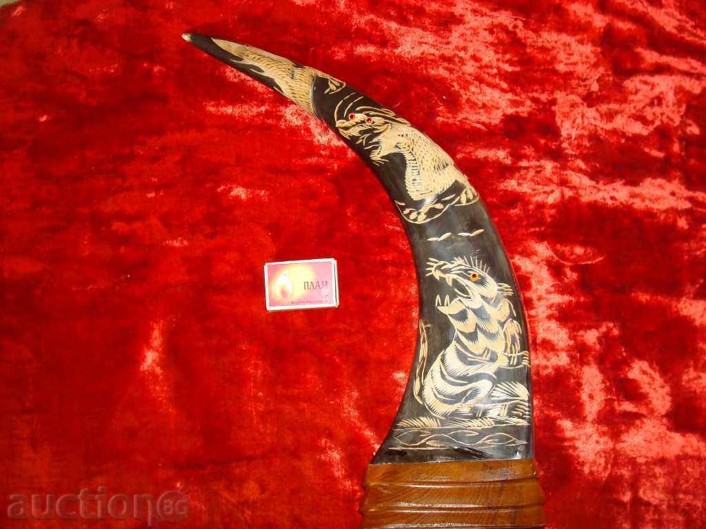 Buffalo horn, carved with a tiger and a dragon on a wooden stand