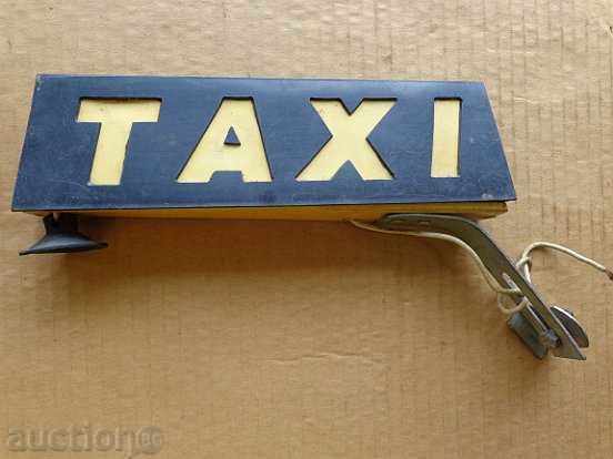 An old plastic plaque of a co-op taxi
