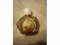 I am selling an old perfume bottle with metal fittings and gilding