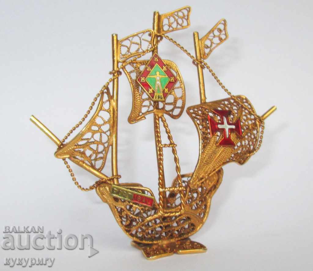 a small canvas ship with a gold-plated hand-made filigree