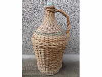 Old wicker demijohn, bottle, flask