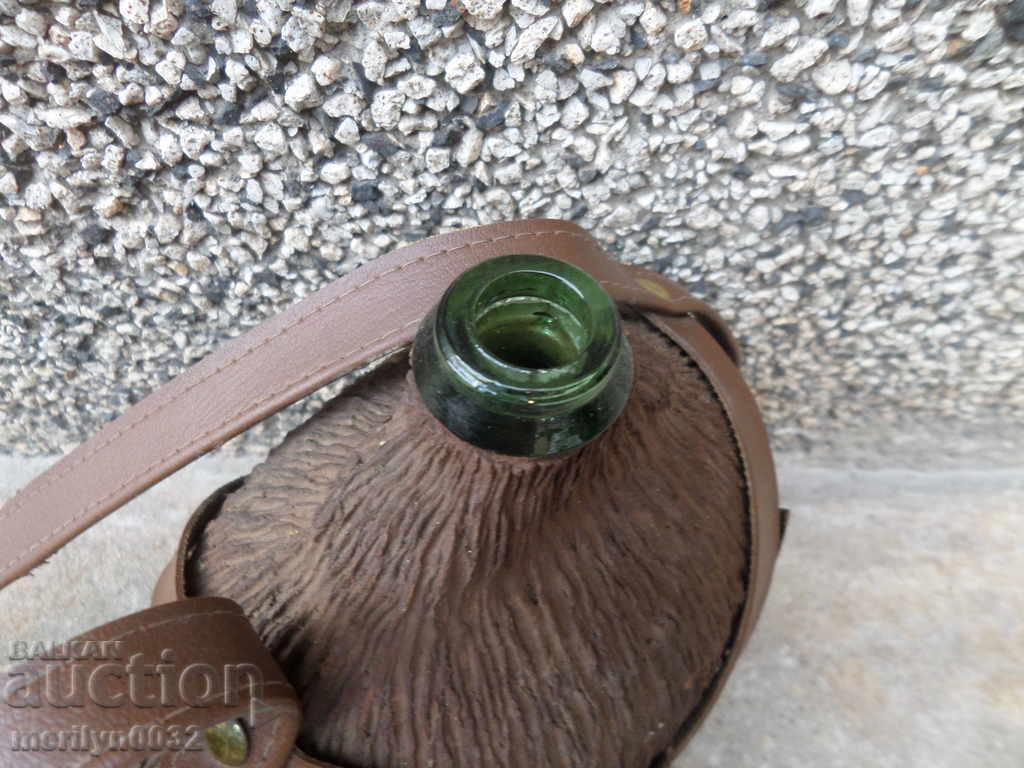 Auction An old glass bottle with a strap Auction An old glass bottle with a strap