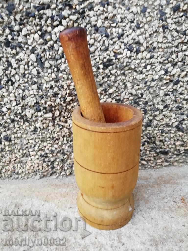 An old wooden mortar with hammer, mortar, chute, wooden