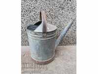 Παλιό μεταλλικό ποτιστήρι, γαλβανισμένος σωλήνας, κουβάς, γλάστρα