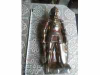 An old cast iron figure for a fireplace. Knight sculpture.