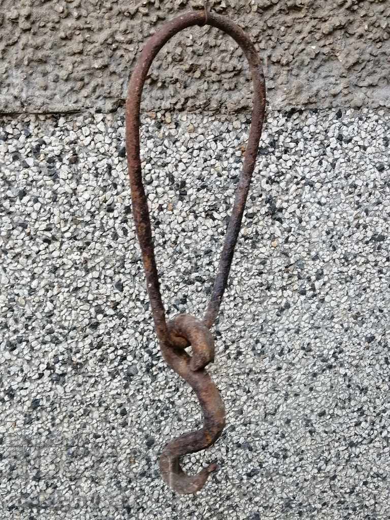 An old forged hook with a ring, a cogger, an anchor wrought iron
