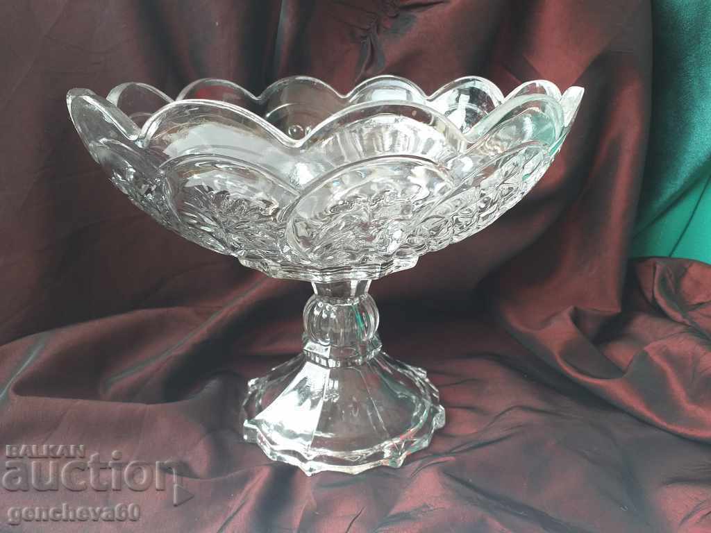 A large old fruit stand with a stool A large old fruit stand with a stool