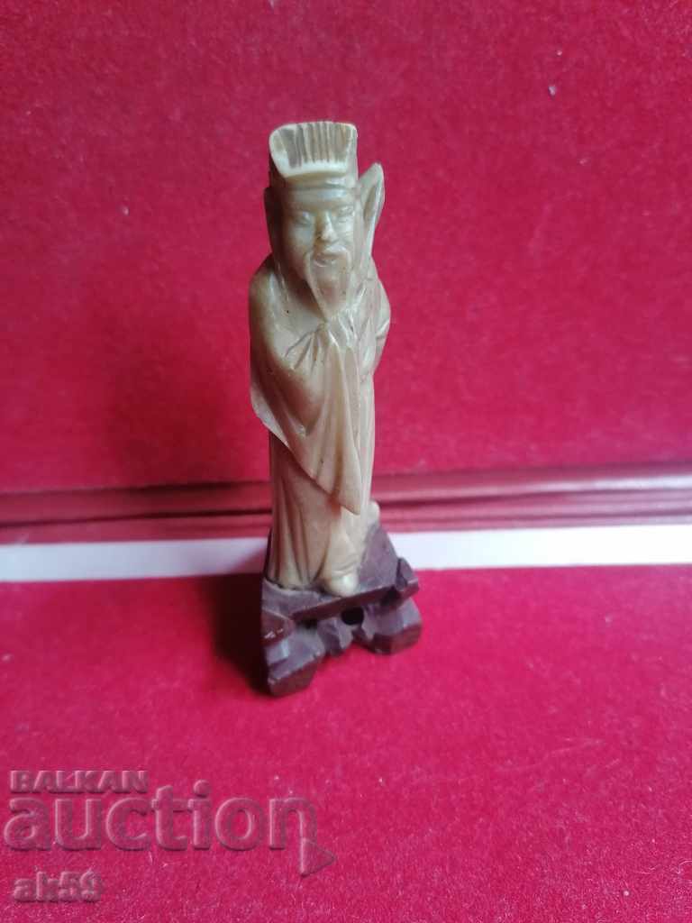An old figurine of a monk from steatite - a small plastic.