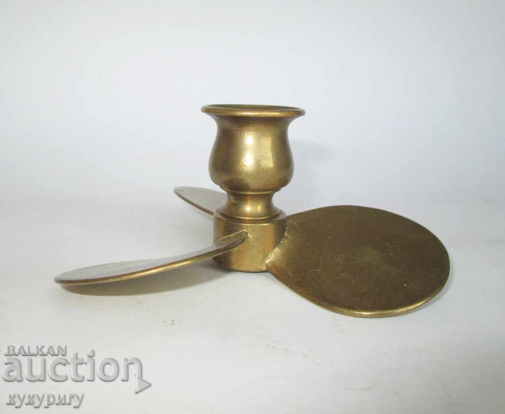 Old bronze small candlestick in the shape of a ship's propeller