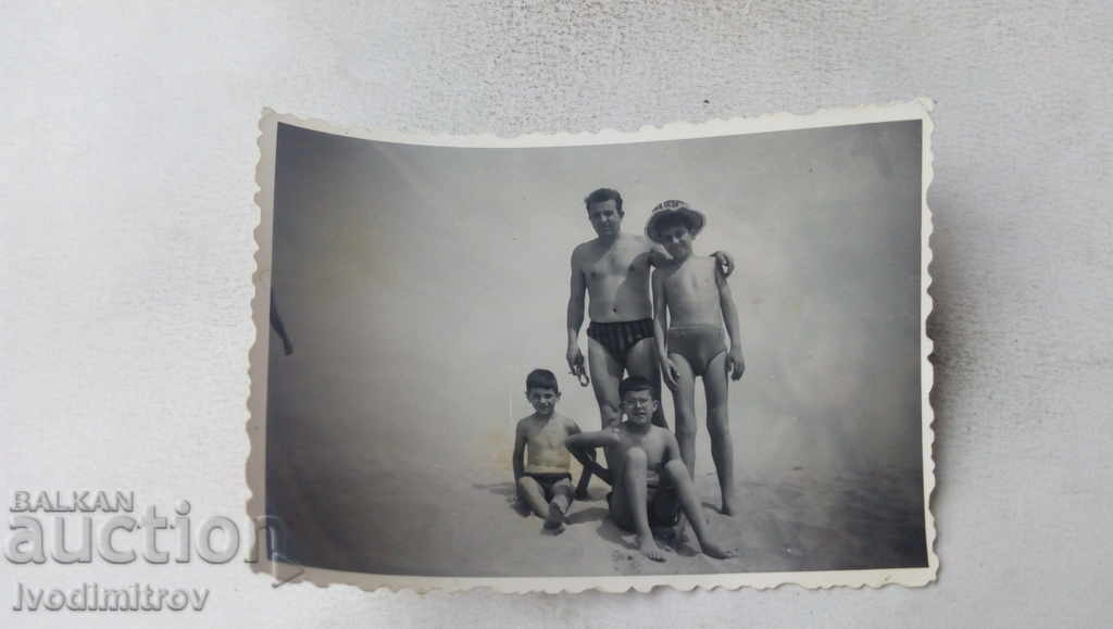 Fotografie Om și copii pe plajă
