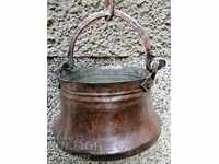 An old copper cauldron crushes a copper copper vessel