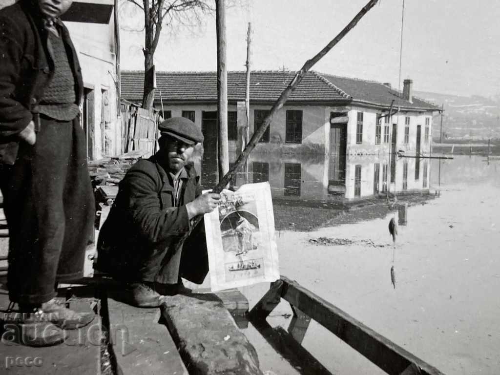 The Lom flood of 1940. A fisherman fishes in the city