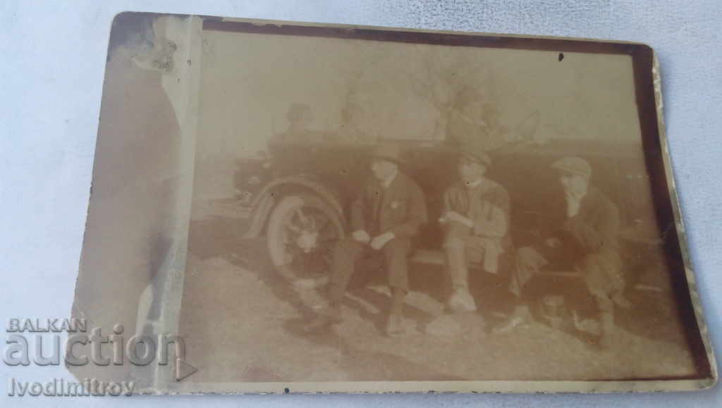 Foto Trei bărbați în fața unei mașini retro