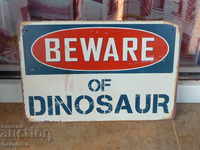 Metal sign inscription Caution dinosaurs Jurassic park teeth