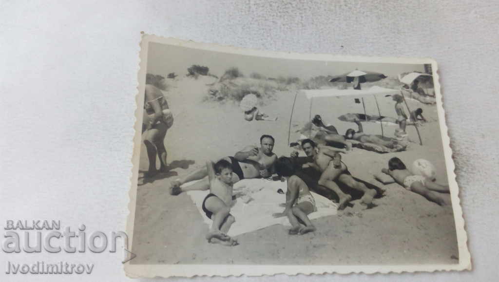 Photo Two men with children on the beach