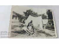 Снимка Двама мъже голи до кръста покрай палатки
