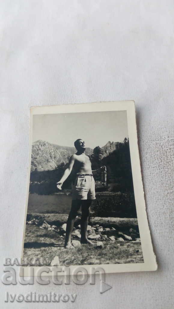 Φωτογραφία Γυμνός άντρας στη μέση με ένα μπουκάλι στο χέρι στα βουνά